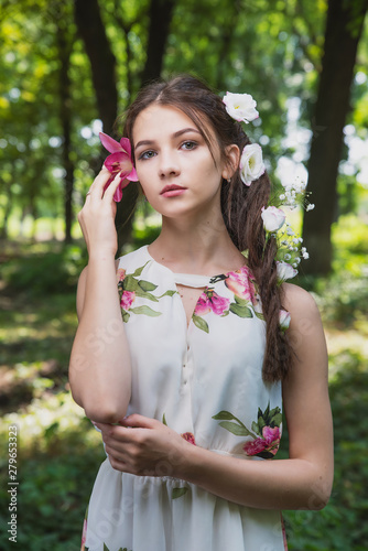 beautiful girl with lilies in her hair  flowers in the luxurious dark hair of a young lady