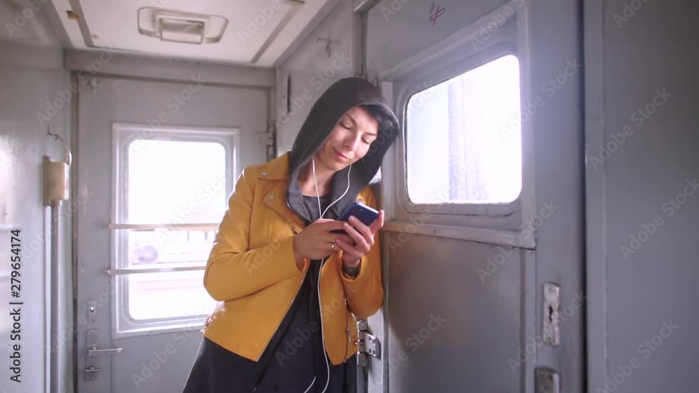 girl uses a smartphone and headphones, thoughtful girl uses a smartphone and headphones, thoughtful