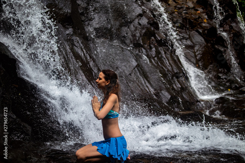 Young Caucasian woman meditating  practicing yoga at waterfall in Ubud  Bali  Indonesia.
