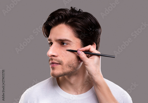 Plastic surgeon drawing guide marks on male patient face
