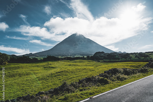 Straight EN3 longitudinal road northeast of Mount Pico and the silhouette of the Mount Pico along , Pico island, Azores, Portugal.