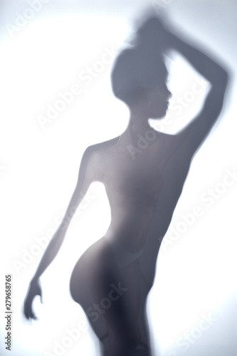 blurred image of young woman with raised arm looking aside. close up photo.