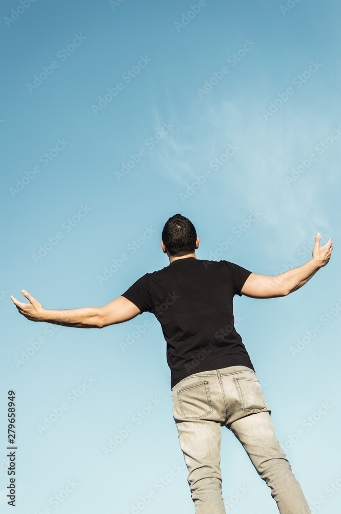 Man looking at the sky and screaming with open arms. Man with background of a clear sky with copy space top. Man looking at the sky and screaming with open arms. Man with background of a clear sky with copy space top.