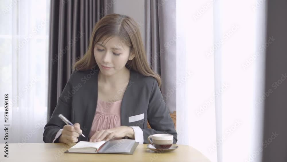 Business woman making notes writing in notebook, relax and happy working at office Business woman making notes writing in notebook, relax and happy working at office