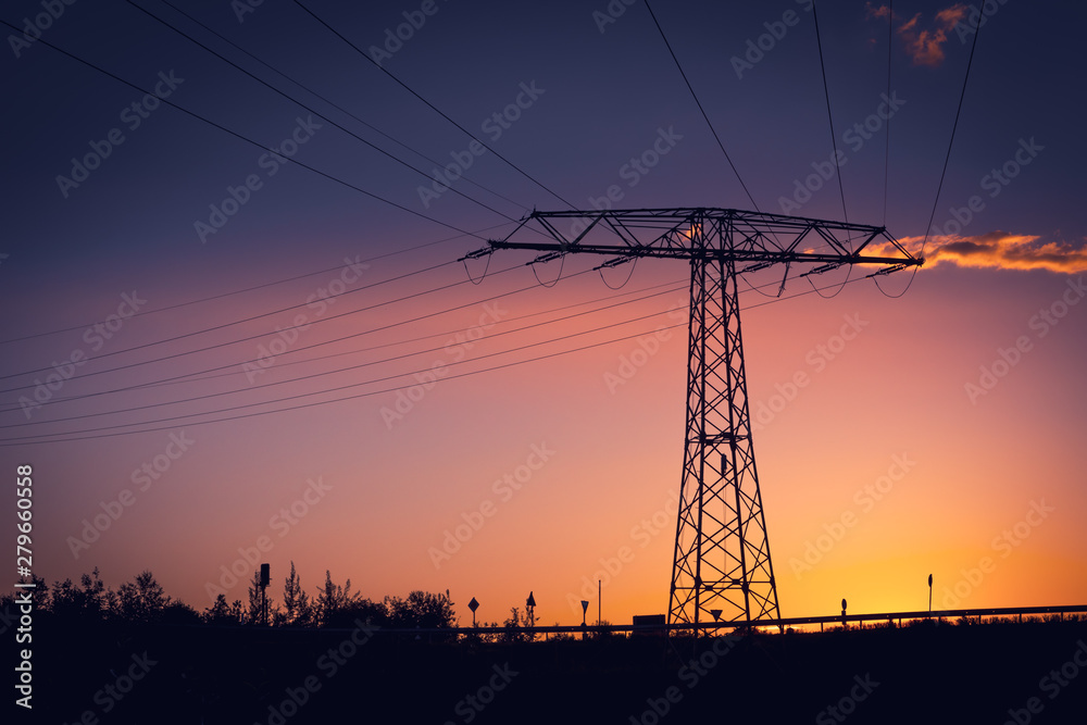 Electricity pylon silhouetted against a sunset