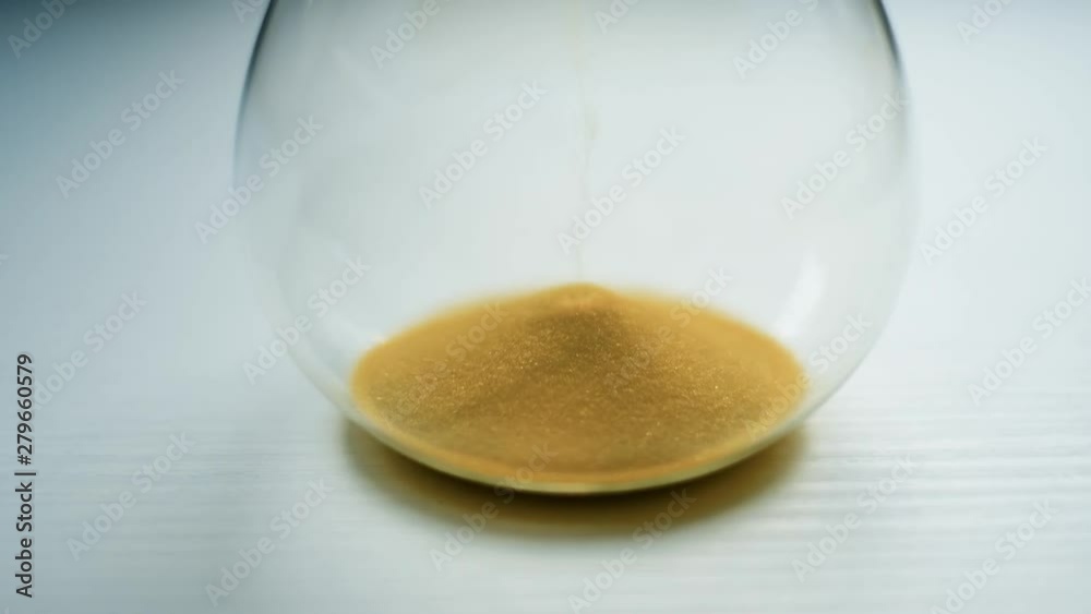 Glass sandwatch with yellow sand on white table. Time and life concept. UHD 4K video Glass sandwatch with yellow sand on white table. Time and life concept. UHD 4K video