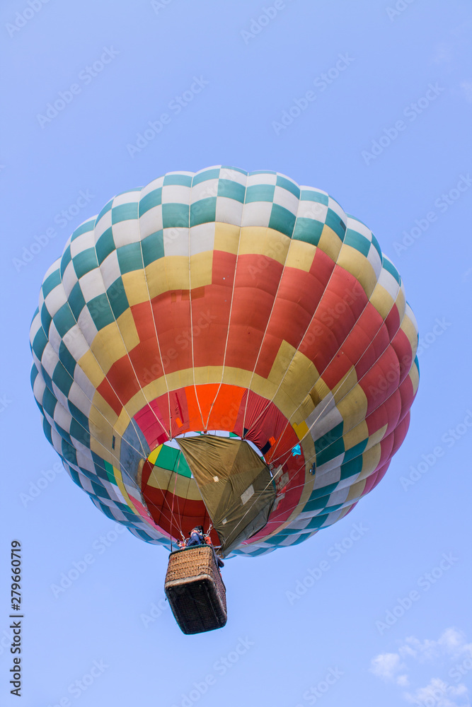 Fototapeta premium flying balloon with passengers in a basket against the blue sky at the festival of Aeronautics in Pereslavl-Zalessky Russia summer evening