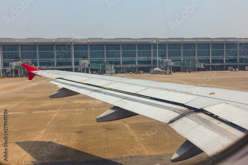 Aircraft wing view from inside plane with aire port at Yangon
