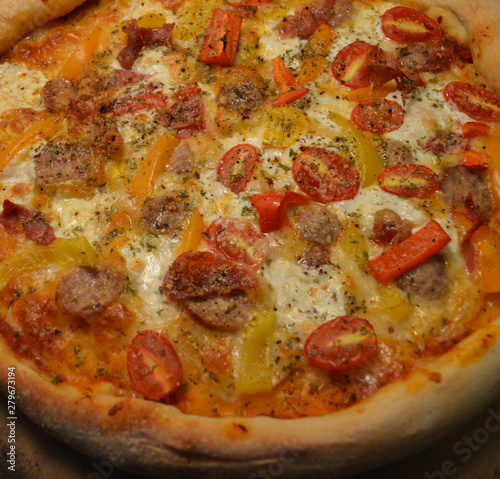 Fresh Home Made Italian Style Pizza Topped with Tomato, Sausage, Mozzarella, and Vegetables