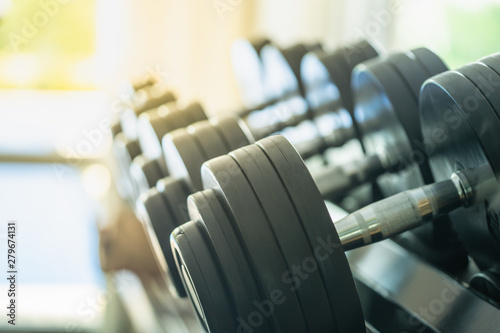 Sport and Fitness Concept. Rows of metal dumbbells on rack in the gym / sport club with copy space. Weight Training Equipment.