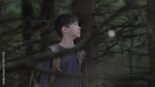 Frightened Boy Walks Through A Terrible Dry Forest In The Evening Looks Around photo