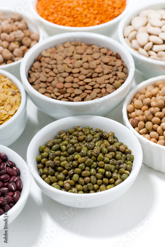 assortment of various legumes in bowls, vertical