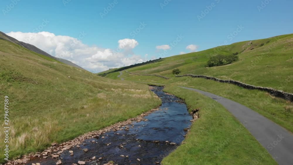 Ascending shot of the Barbon Beck Valley, Carnforth, Lancashire. This stunning countryside features a stream running alongside a small country lane. Ascending shot of the Barbon Beck Valley, Carnforth, Lancashire. This stunning countryside features a stream running alongside a small country lane.