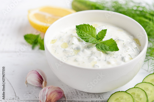 Obraz na plátně Greek dip sauce or dressing tzatziki and ingredients decorated with olive oil an