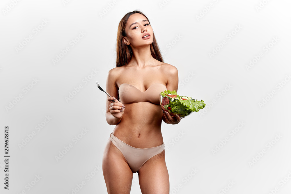 Young sexy brunette woman holding vegetable salad isolated on white background. close up photo. lifestyle, free time, spare time Young sexy brunette woman holding vegetable salad isolated on white background. close up photo. lifestyle, free time, spare time