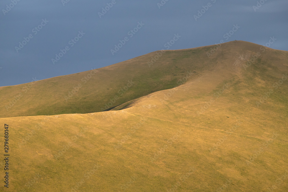Natural landscape of the plain of Castelluccio di Norcia in the warm light of the sunset. Apennines, Umbria, Italy