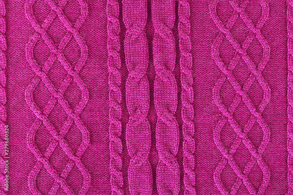 Background from a fabric texture. Wool knitted fabric with cable seamless pattern of pink-red color. Textile closeup.Openwork drawing fuchsia. Concept of example, learning of knitting,concept of cover Background from a fabric texture. Wool knitted fabric with cable seamless pattern of pink-red color. Textile closeup.Openwork drawing fuchsia. Concept of example, learning of knitting,concept of cover