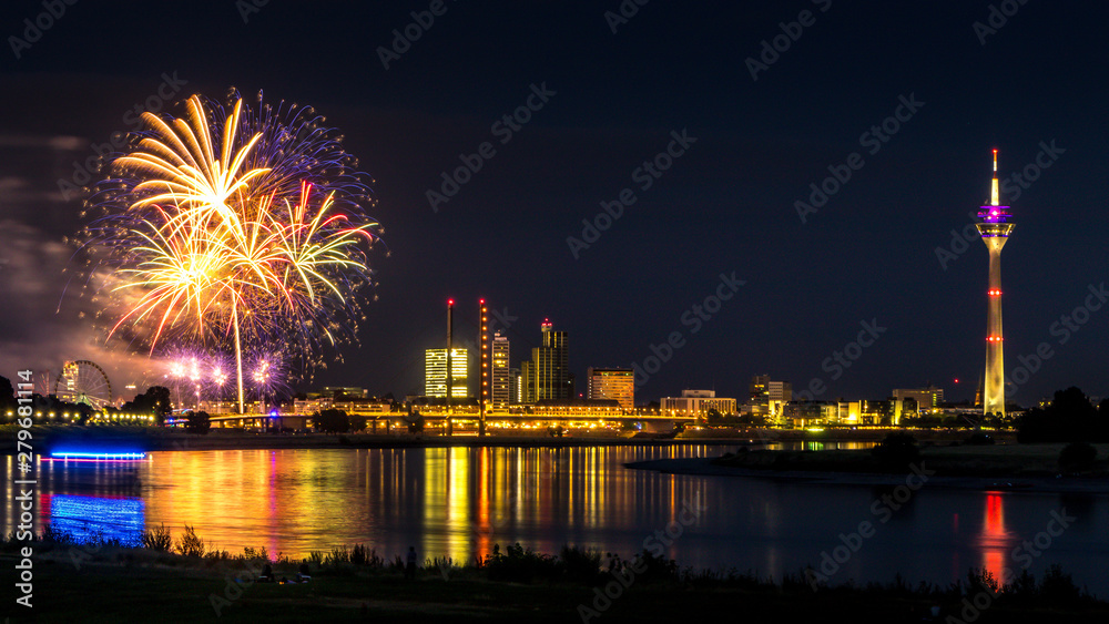Die Skyline von Düsseldorf am Rhein ist in der Nacht mit Feuerwerk zur Rheinkirmes besonders schön