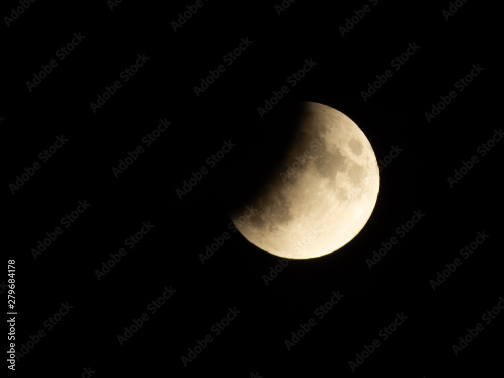 Naklejka premium Progressing partial lunar eclipse with visible lunar seas and craters on moon surface