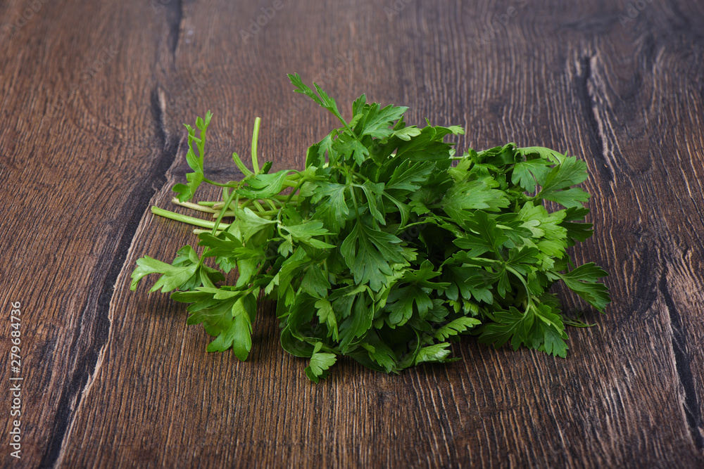 Fresh parsley leaves on wooden table. Close up. Fresh parsley leaves on wooden table. Close up.