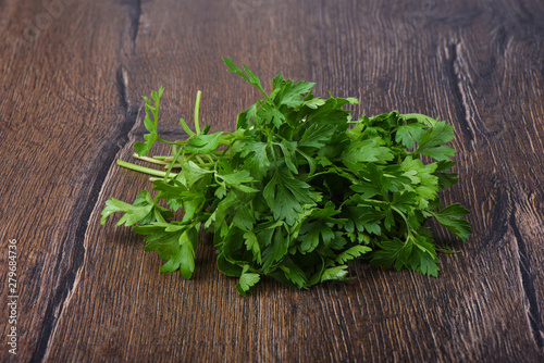 Fresh parsley leaves on wooden table. Close up.