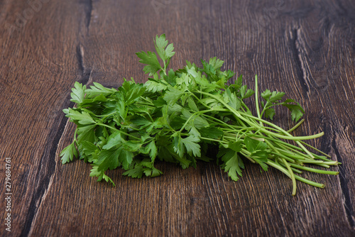 Fresh parsley leaves on wooden table. Rustic style.