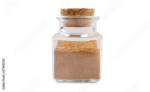 milled or ground nutmeg in glass  jar on isolated on white background. front view. spices and food ingredients.