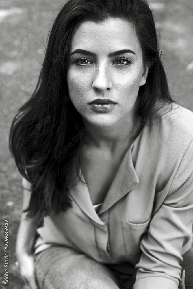Young woman sitting outdoors black and white portrait Young woman sitting outdoors black and white portrait