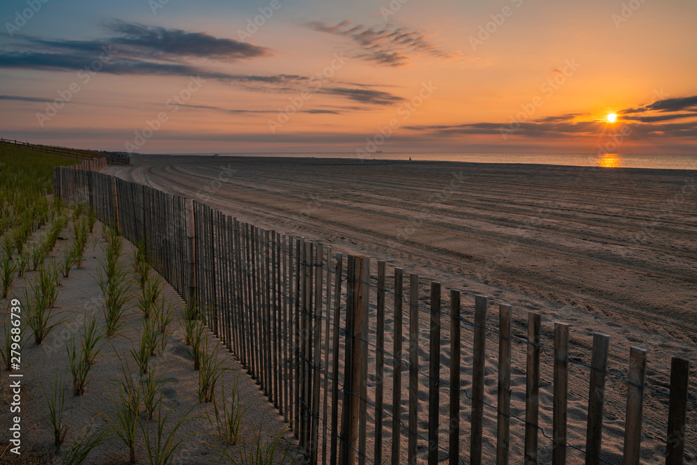 Beautiful sunrise over Lavallette Beach, New Jersey featuring sand on the foreground and sunny sky on the background