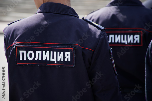 Russian police officers during a patrol on a city street. View from the back