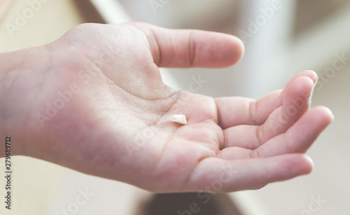 Child holding his fallen milk tooth on his hand.