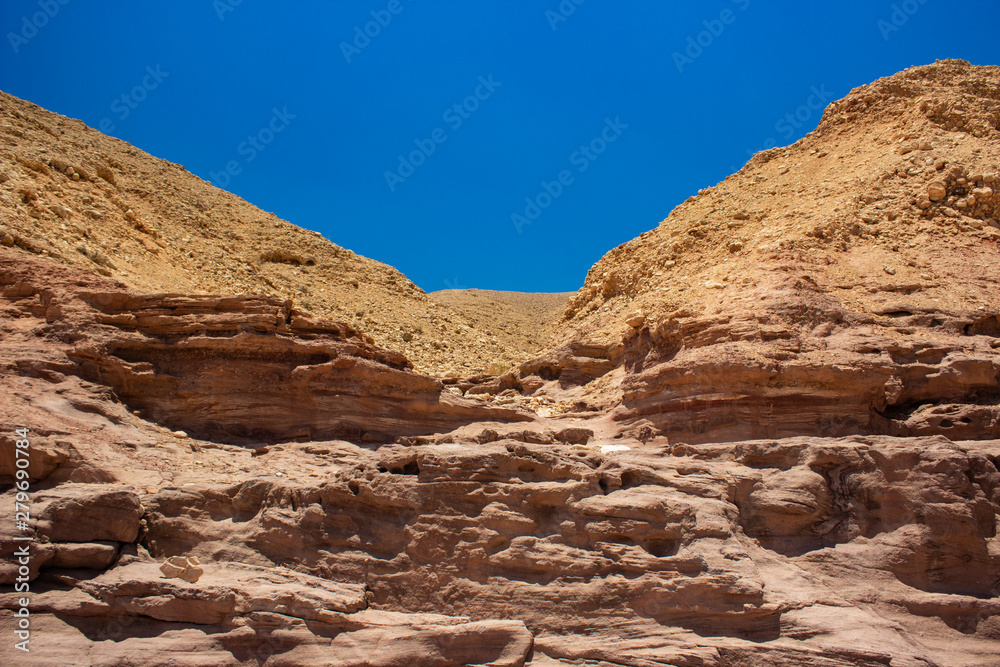 symmetry frame photography of bare rock in Israeli desert scenery landscape with empty blue sky background  