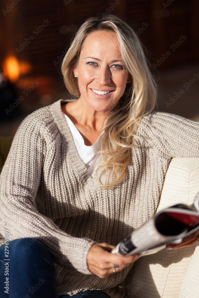 Caucasien woman smiling at the camera. She is reading a magazine. Happy at the hotel Caucasien woman smiling at the camera. She is reading a magazine. Happy at the hotel