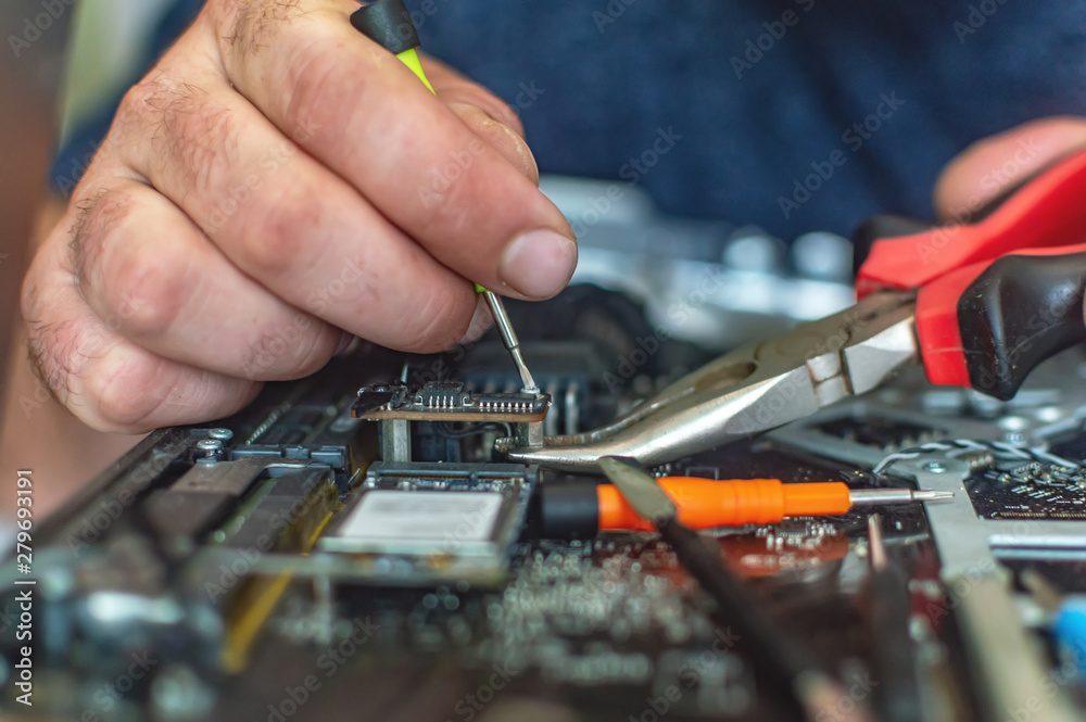 a man repairs a computer, solders a board, repairs electronics and modern technologies a man repairs a computer, solders a board, repairs electronics and modern technologies