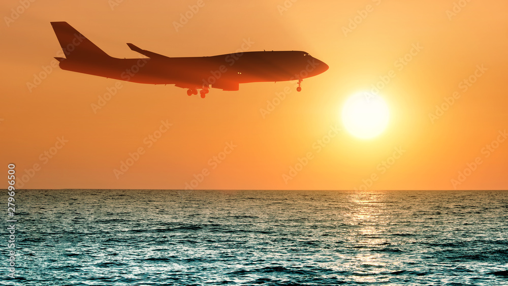 airplane flying over sea water on sunset sky background side panorama  landscape view of passenger jet plane landing and setting sun reflection on  ocean water air travel aircraft silhouette wallpaper Stock Photo |