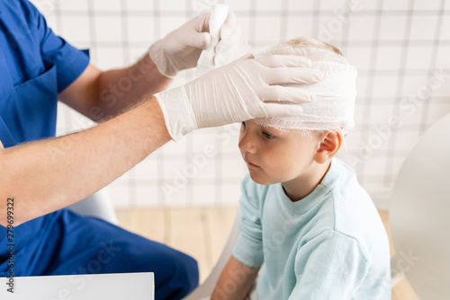 Wallpaper Mural Sports injury. Doctor makes bandage on head patient, in the hospital. Torontodigital.ca