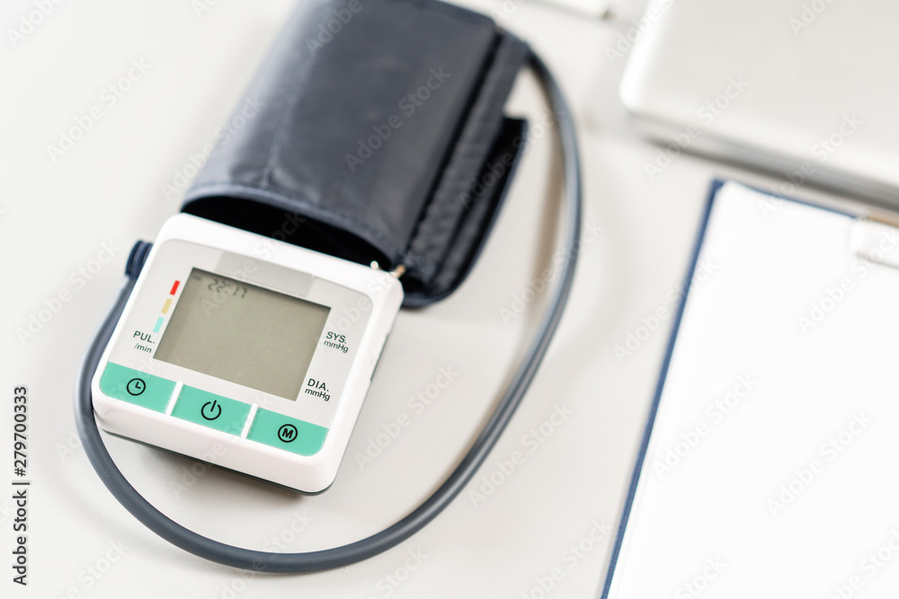 Workplace of doctor with laptop, stethoscope and notebook on wooden table in the office. Blood Pressure Monitor. Medical equipment. Cardiac diagnosis. vintage tone. Workplace of doctor with laptop, stethoscope and notebook on wooden table in the office. Blood Pressure Monitor. Medical equipment. Cardiac diagnosis. vintage tone.