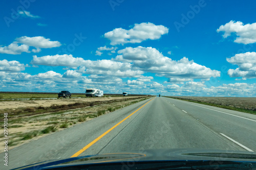 Windshield view of road trip in central California, approaching Highway 5 on a partly cloudy early spring day. 
