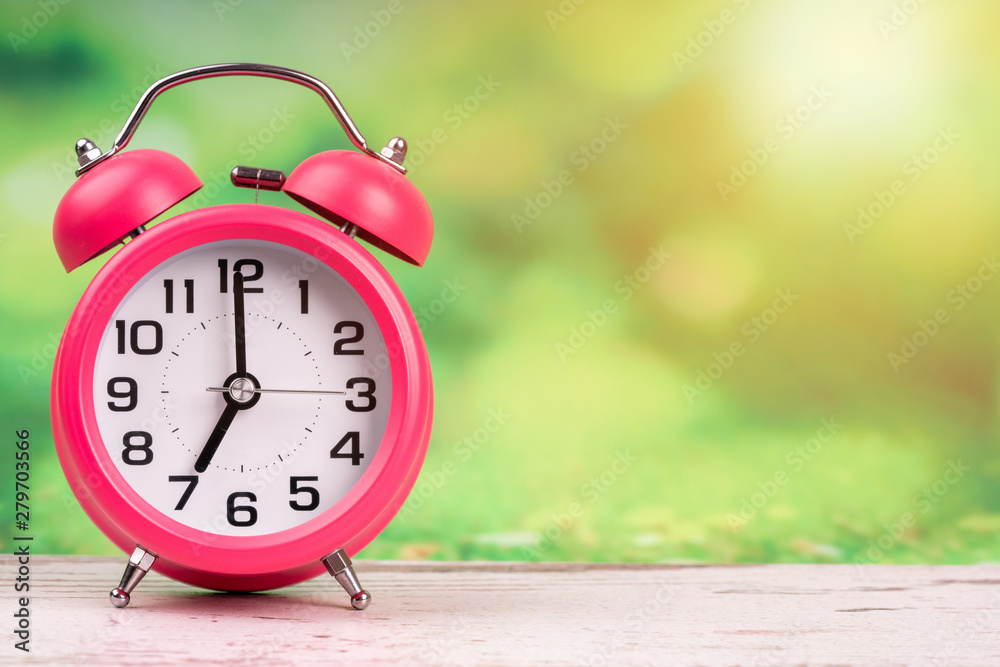 alarm clock on wooden and green background alarm clock on wooden and green background