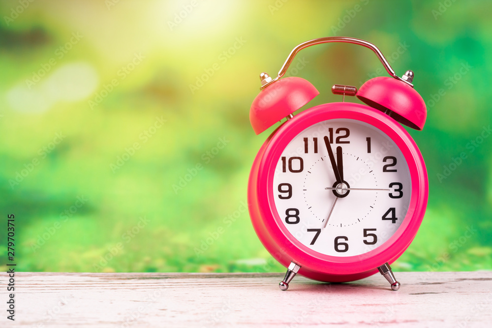 alarm clock on wooden and green background alarm clock on wooden and green background