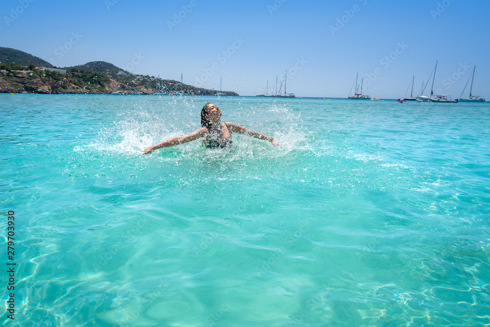 Ibiza bikini girl splashing clear water beach