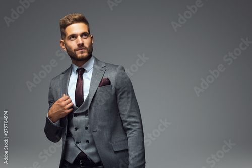 Stylish young man in suit and tie. Business style. Fashionable image. Office worker. Sexy man standing and looking at the camera