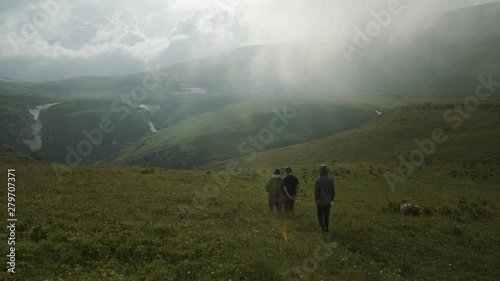 A group of people walking through mountain meadows
