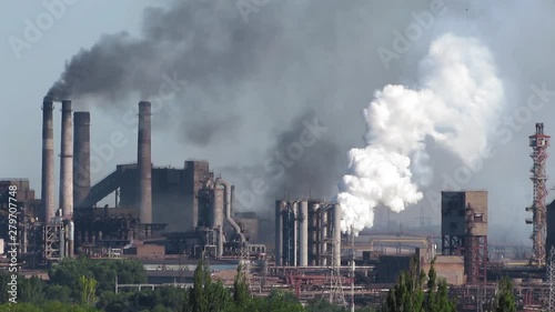 Air pollutants emissions - high amount. Toxic smoke of air pollutants, released into the atmosphere by chimney smoking stack at by-product coke plant in metallurgy industry, pollutes the environment.