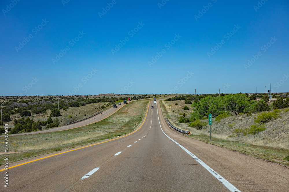 Long highway in the american countryside, blue cloudy sky background Long highway in the american countryside, blue cloudy sky background