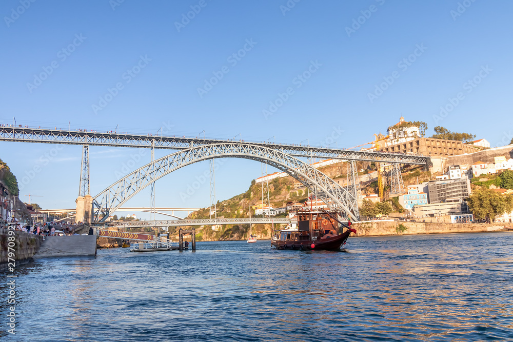 Tourist boat in Porto, Portugal, in front of Dom Luis Bridge