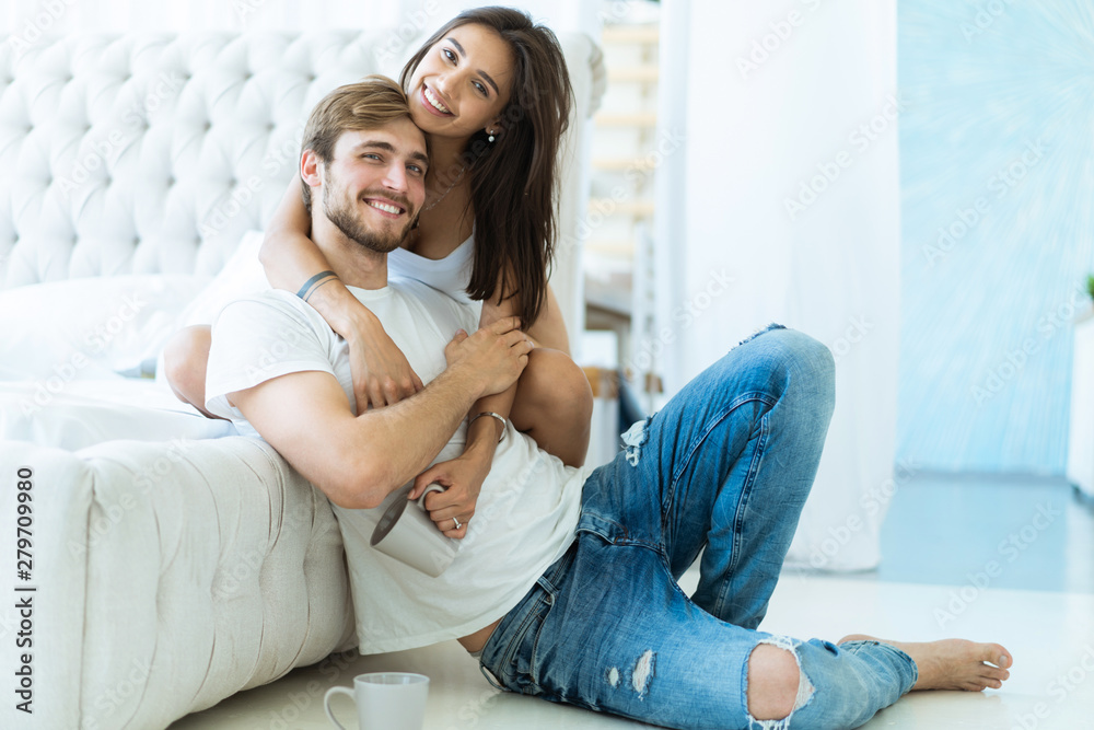 Loving young couple hugging and relaxing on sofa at home. Loving young couple hugging and relaxing on sofa at home.