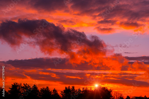 Fiery orange sunset colorful and speckled clouds.