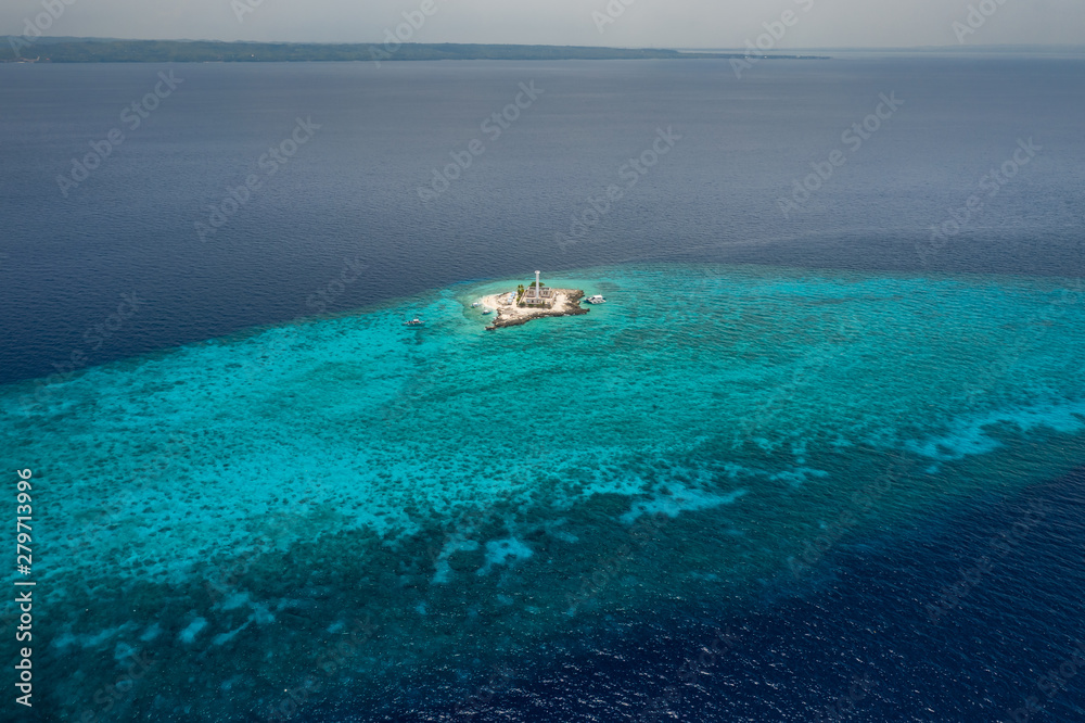 Aerial view of a tiny tropical island with a lighthouse surrounded by a huge coral reef (Capitancillo Island, Philippines) Aerial view of a tiny tropical island with a lighthouse surrounded by a huge coral reef (Capitancillo Island, Philippines)