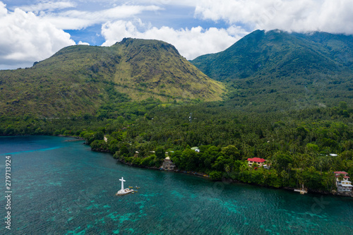 Fototapeta Naklejka Na Ścianę i Meble -  Aerial view of the sunken cemetery off the coast of the green volcanic island of Camiguin
